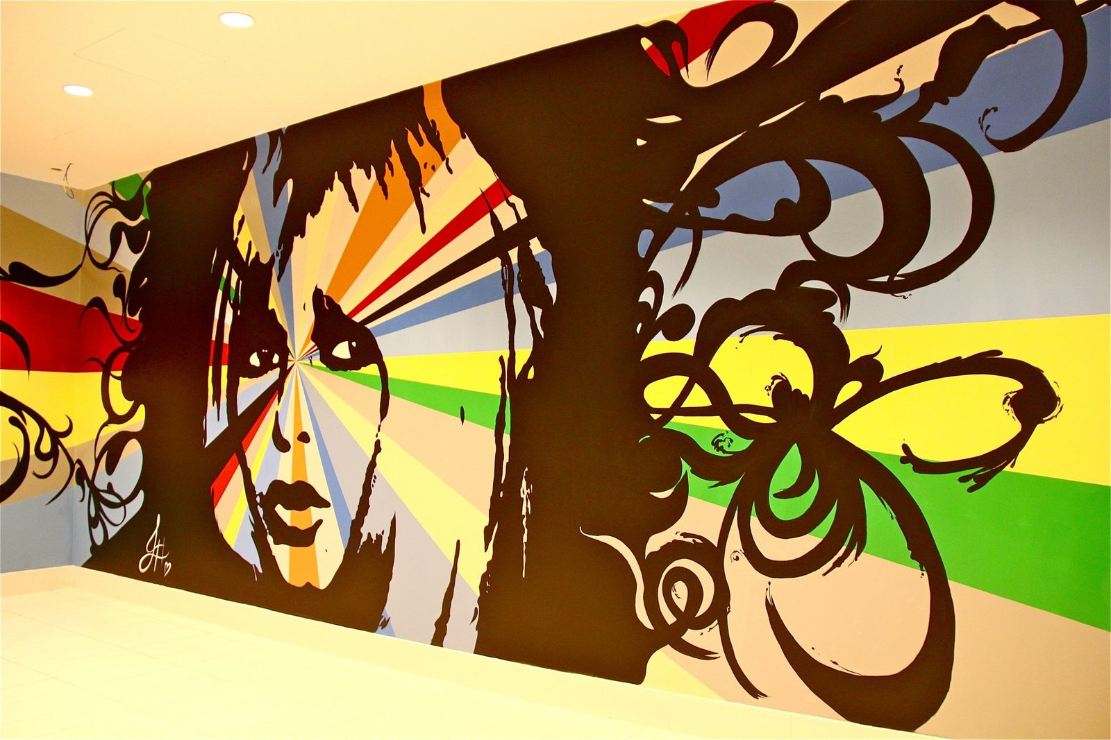 A wide interior mural with a pop face and butterflies
