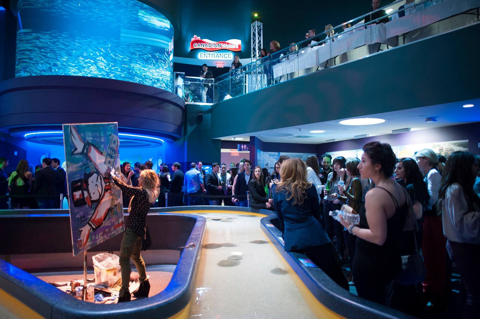 Jessica painting live in front of a large crowd at Ripley's Aquarium