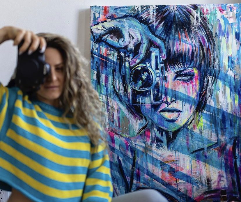 Jessica photographing a blue mixed-media portrait