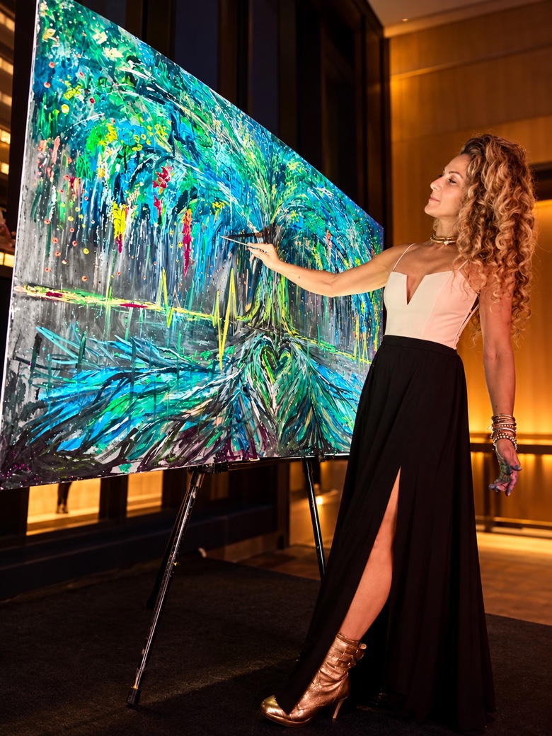 Jessica in an evening gown painting a large abstract canvas live